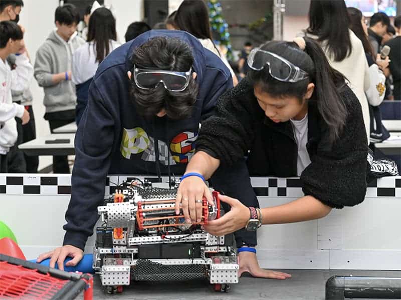 Students checking on their robots at the 2023 VEX Signature Event held in Pacific American School
